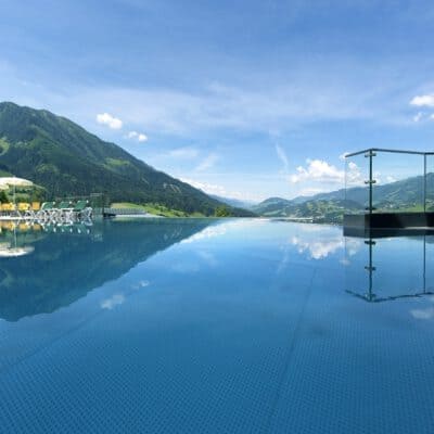 Alpinas Rooftop Pool mit Ausblick auf die umliegende Bergwelt