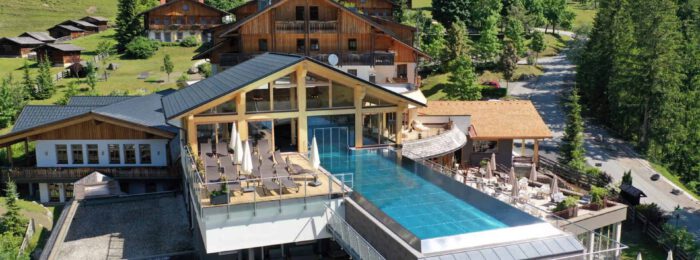 Das SKY Infinity Pool des Almwellness-Resort Tuffbad im Kärntner Lesachtal im Sommer.