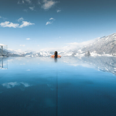 Alpinas Rooftop Pool mit Ausblick auf die umliegende Bergwelt